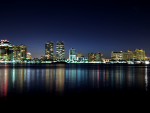 Fianzas en Miami, FL' against a backdrop of the Miami skyline at sunset.